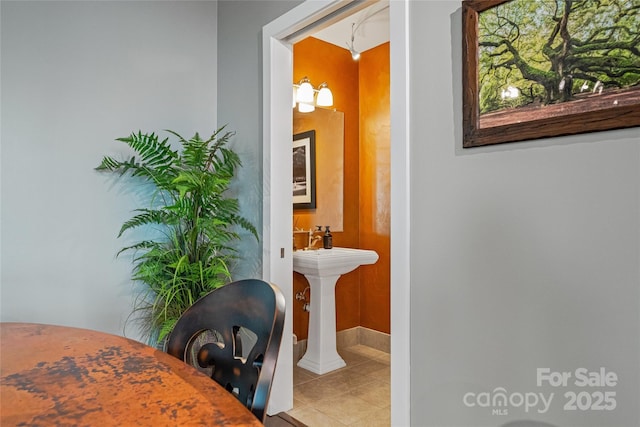interior space with tile patterned floors, baseboards, and a soaking tub