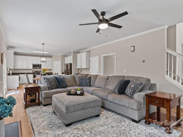 3 Holmes Ln, Arden, NC 28704 - living room featuring ornamental molding, light wood finished floors, stairs, and ceiling fan with notable chandelier