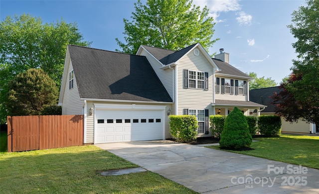 traditional-style house featuring fence, an attached garage, a front lawn, a chimney, and driveway