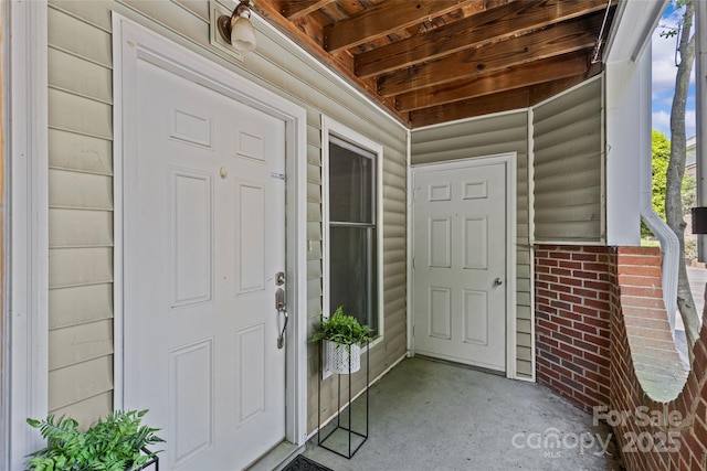 view of exterior entry featuring brick siding
