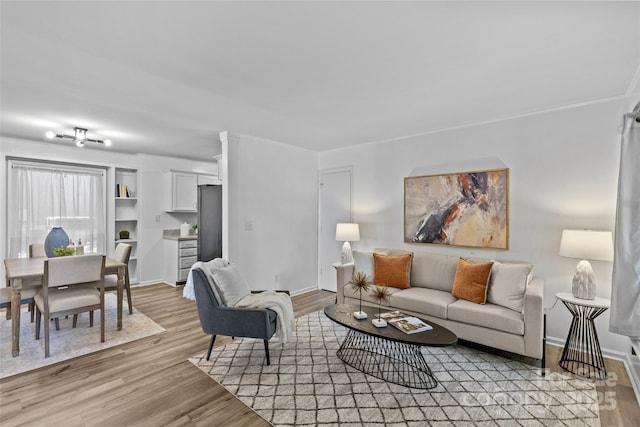 living area featuring baseboards and light wood-style floors