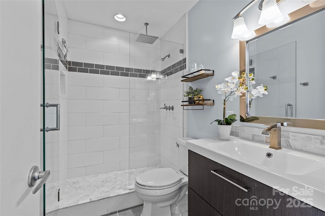 full bathroom featuring toilet, a shower stall, and vanity