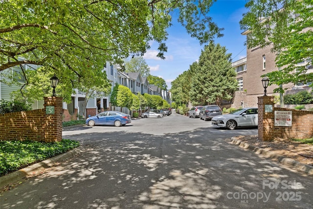view of street with curbs, street lights, and a residential view