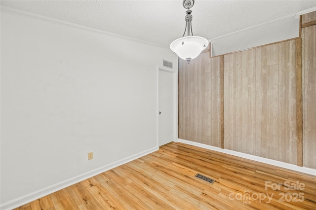 1005 Caldon Dr, Stanley, NC 28164 - spare room with wood finished floors, wood walls, a textured ceiling, and ornamental molding