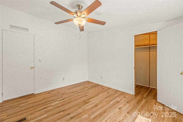 1005 Caldon Dr, Stanley, NC 28164 - unfurnished bedroom featuring a walk in closet, light wood-style floors, a closet, and a ceiling fan