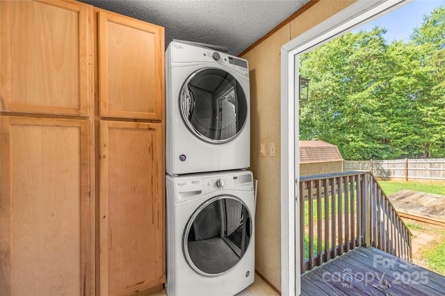 1005 Caldon Dr, Stanley, NC 28164 - washroom featuring stacked washer / dryer, cabinet space, and a textured ceiling