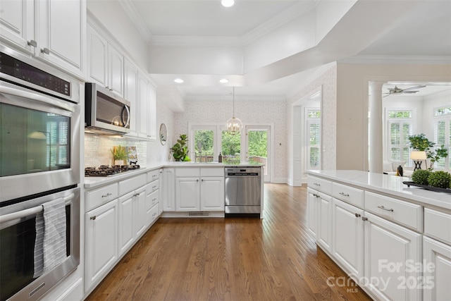 kitchen with light countertops, stainless steel appliances, dark wood-style flooring, and white cabinetry