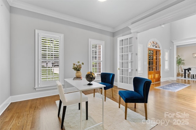 dining room featuring crown molding, baseboards, wood finished floors, and french doors