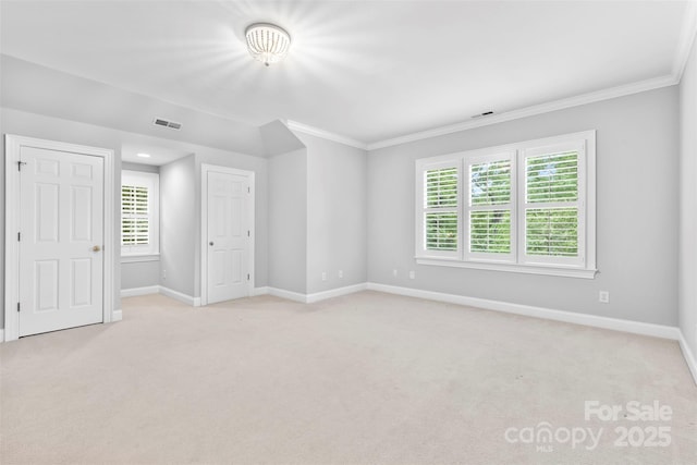 interior space featuring crown molding, baseboards, and light colored carpet