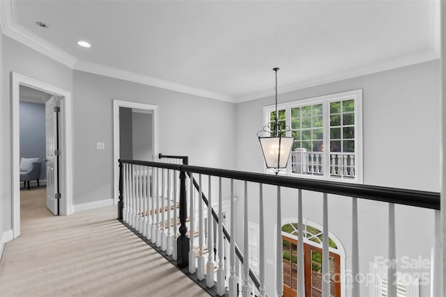 hallway with baseboards, crown molding, a chandelier, and an upstairs landing