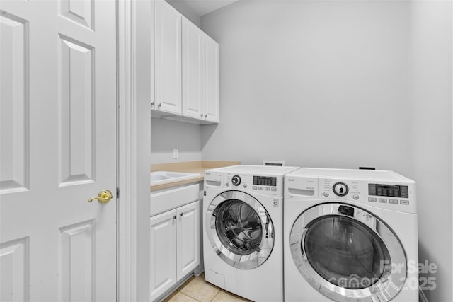 laundry room with light tile patterned flooring, cabinet space, and washer and dryer