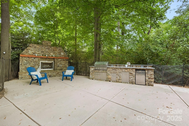 view of patio featuring area for grilling, an outdoor stone fireplace, and fence