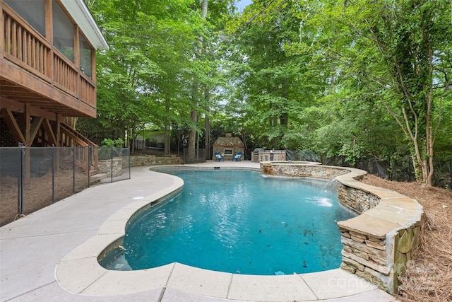 view of pool with a fenced backyard, a pool with connected hot tub, and a patio area