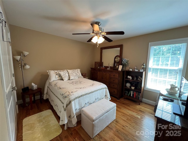 bedroom with baseboards, ceiling fan, and light wood finished floors