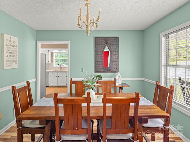 103 Higgins Rd, Fletcher, NC 28732 - dining area featuring light wood-style flooring, an inviting chandelier, and a textured ceiling