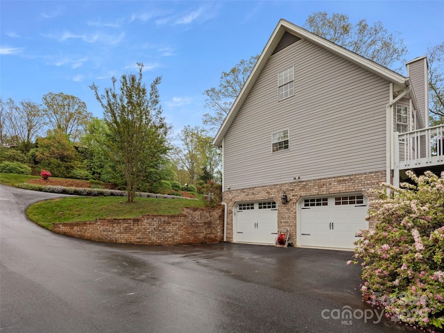 103 Higgins Rd, Fletcher, NC 28732 - view of side of home featuring an attached garage, brick siding, driveway, and a chimney