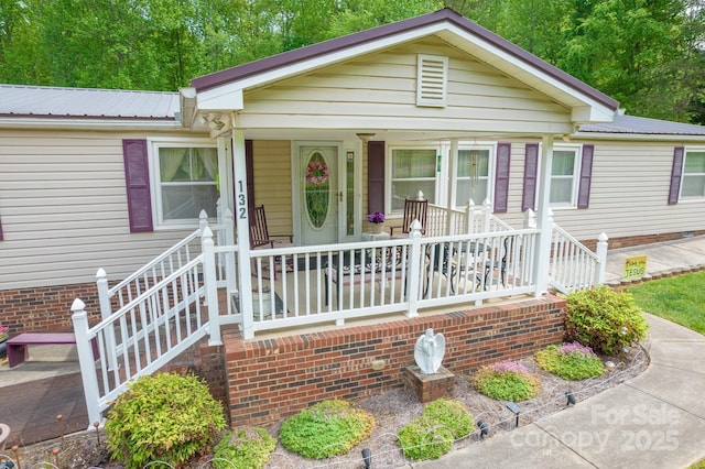 view of front of property featuring metal roof and a porch