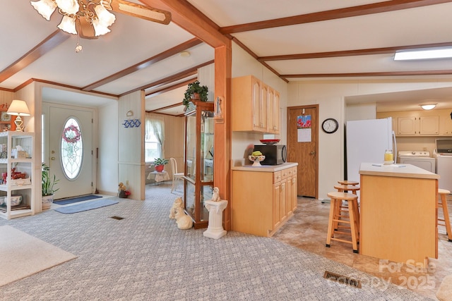 kitchen with lofted ceiling with beams, black microwave, independent washer and dryer, and light countertops