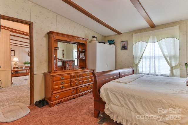 bedroom featuring wallpapered walls, vaulted ceiling with beams, and light colored carpet
