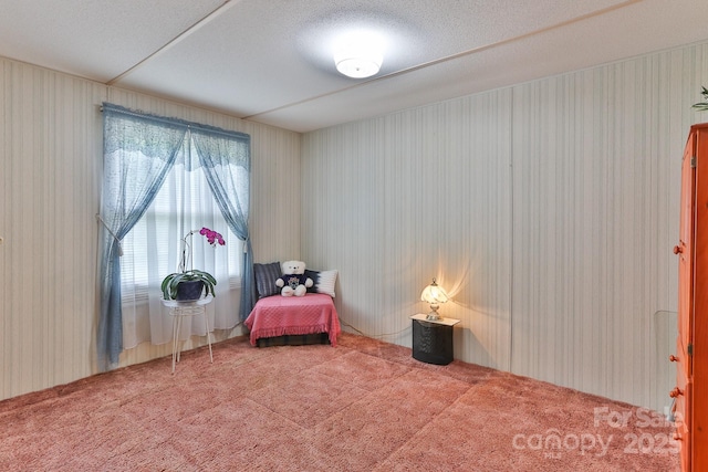 living area with wallpapered walls and carpet