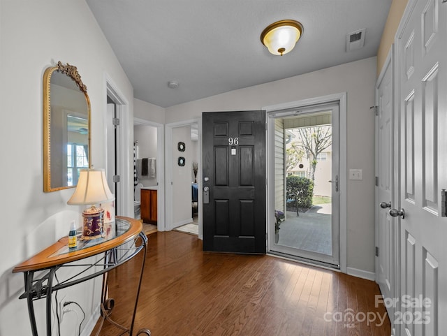 entryway featuring visible vents, baseboards, and dark wood-type flooring