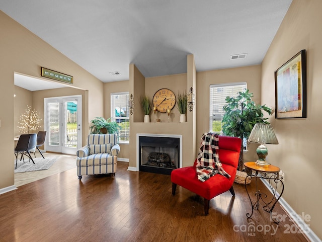 sitting room with a healthy amount of sunlight, wood finished floors, and visible vents