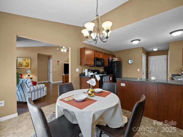 dining space featuring light tile patterned floors, baseboards, and ceiling fan with notable chandelier