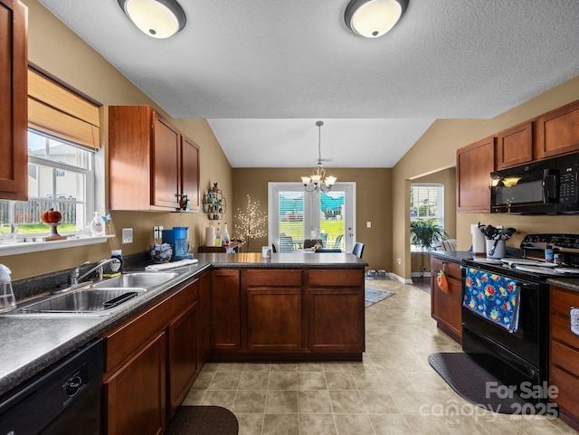 kitchen with dark countertops, a sink, black appliances, a peninsula, and a notable chandelier