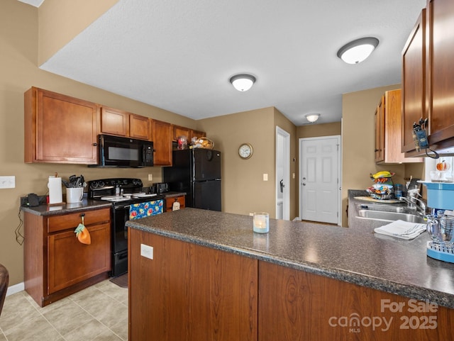 kitchen with a sink, dark countertops, black appliances, and a peninsula