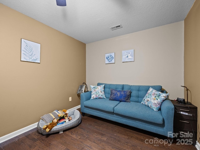 living area with visible vents, baseboards, and wood finished floors