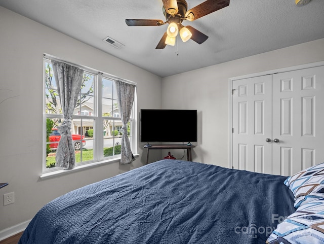 bedroom featuring baseboards, multiple windows, ceiling fan, and visible vents