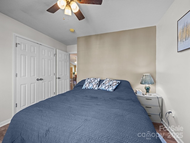 bedroom with a closet, baseboards, ceiling fan, and wood finished floors