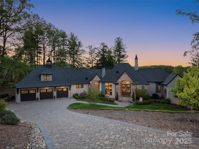 41 Bear Flower Trl, Arden, NC 28704 - french country style house featuring decorative driveway, a garage, and a chimney