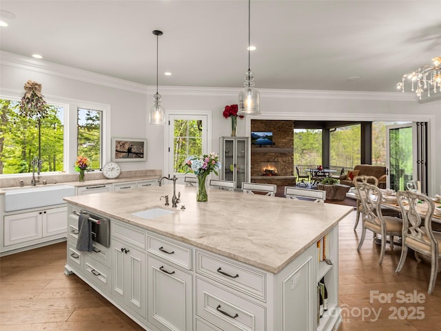 41 Bear Flower Trl, Arden, NC 28704 - kitchen featuring a sink, white cabinetry, light stone countertops, a fireplace, and ornamental molding