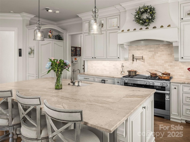 41 Bear Flower Trl, Arden, NC 28704 - kitchen with gas stove, custom range hood, a sink, light stone counters, and a breakfast bar
