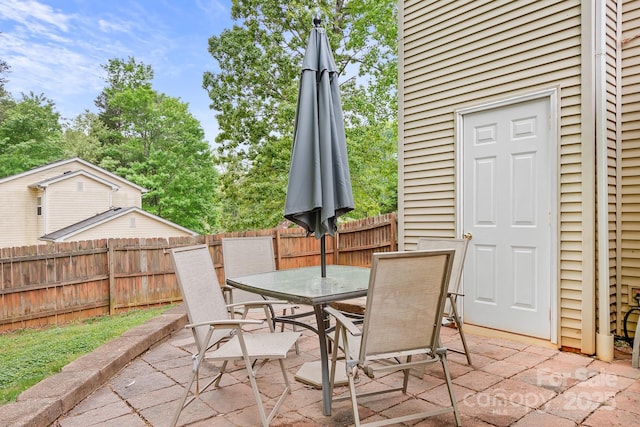 view of patio with outdoor dining space and fence
