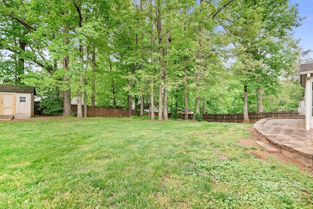 view of yard featuring an outdoor structure, a shed, and a fenced backyard