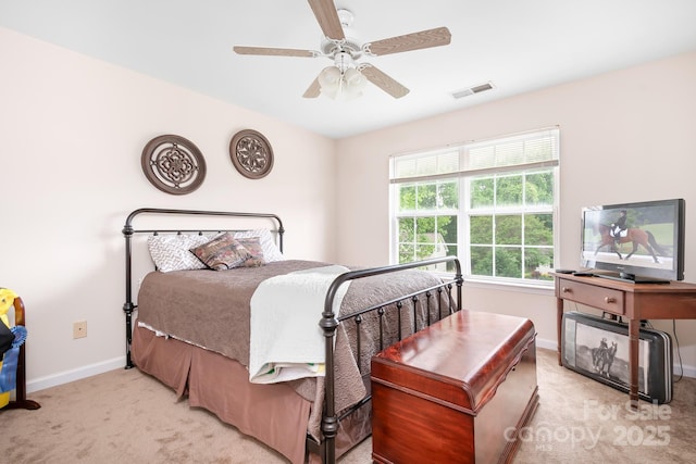 bedroom with a ceiling fan, visible vents, light colored carpet, and baseboards