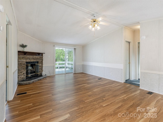 unfurnished living room with a textured ceiling, vaulted ceiling, and wood finished floors