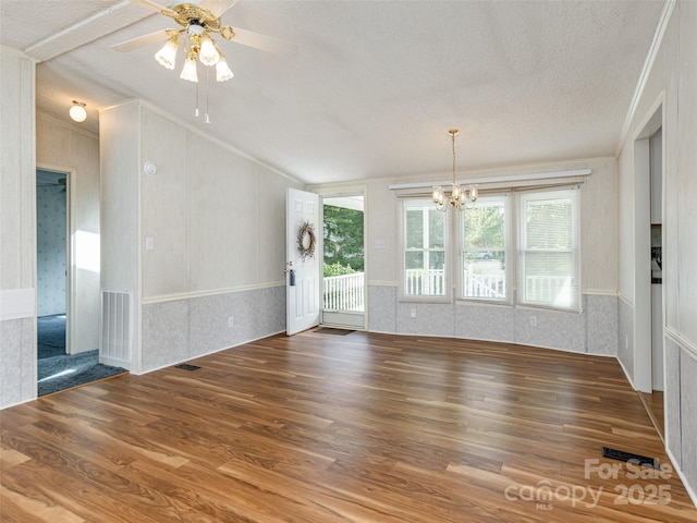 spare room with wood finished floors, a textured ceiling, and crown molding