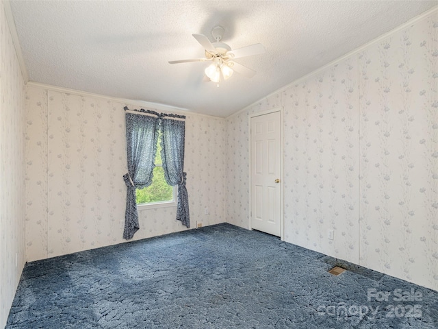 empty room with crown molding, a textured ceiling, carpet flooring, and wallpapered walls