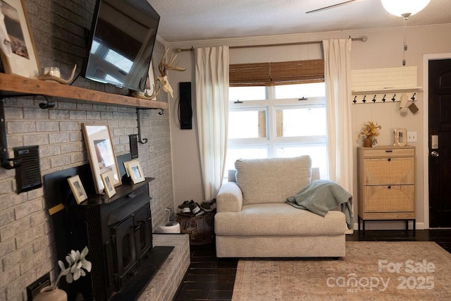 living area featuring crown molding, wood finished floors, and a wood stove