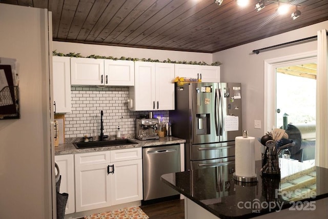 kitchen featuring appliances with stainless steel finishes, a sink, white cabinetry, backsplash, and wood ceiling