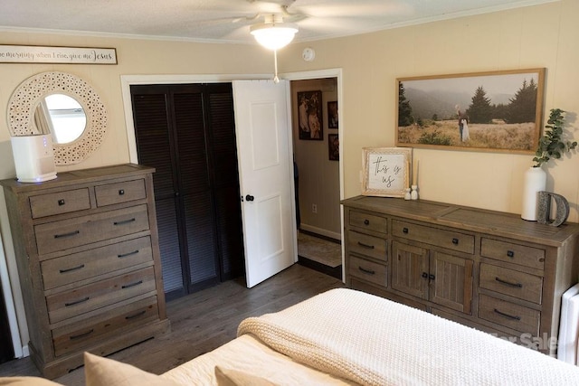 bedroom with crown molding, a ceiling fan, a closet, and dark wood-style flooring