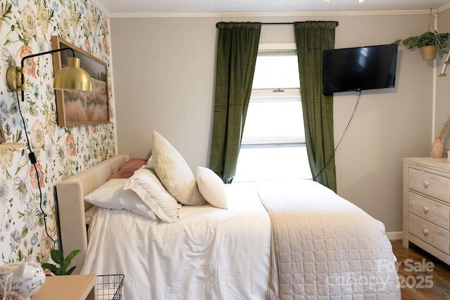bedroom featuring baseboards, ornamental molding, and wood finished floors