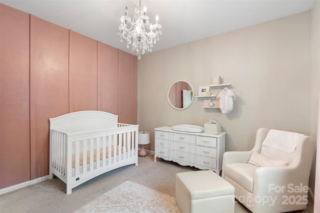 bedroom with a nursery area, baseboards, light carpet, and a chandelier