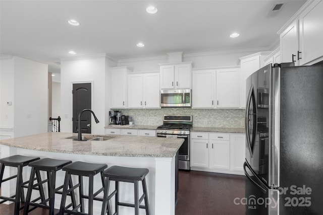 kitchen featuring a sink, appliances with stainless steel finishes, dark wood-style floors, and white cabinetry