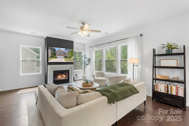 living room featuring a ceiling fan, dark wood finished floors, and ornamental molding