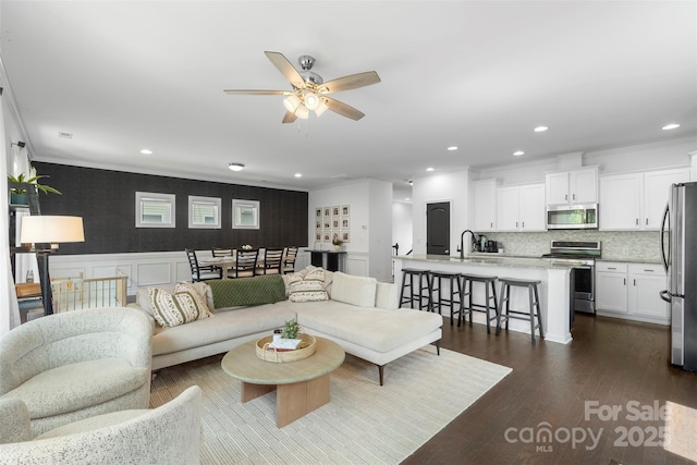 living room featuring recessed lighting, ornamental molding, dark wood-style flooring, and a ceiling fan