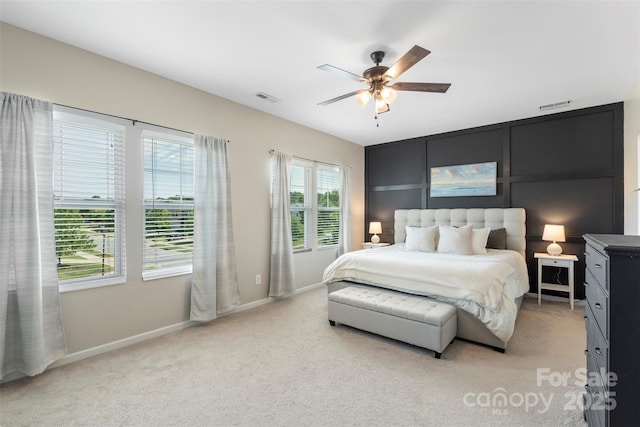 bedroom with visible vents, a ceiling fan, baseboards, and light colored carpet